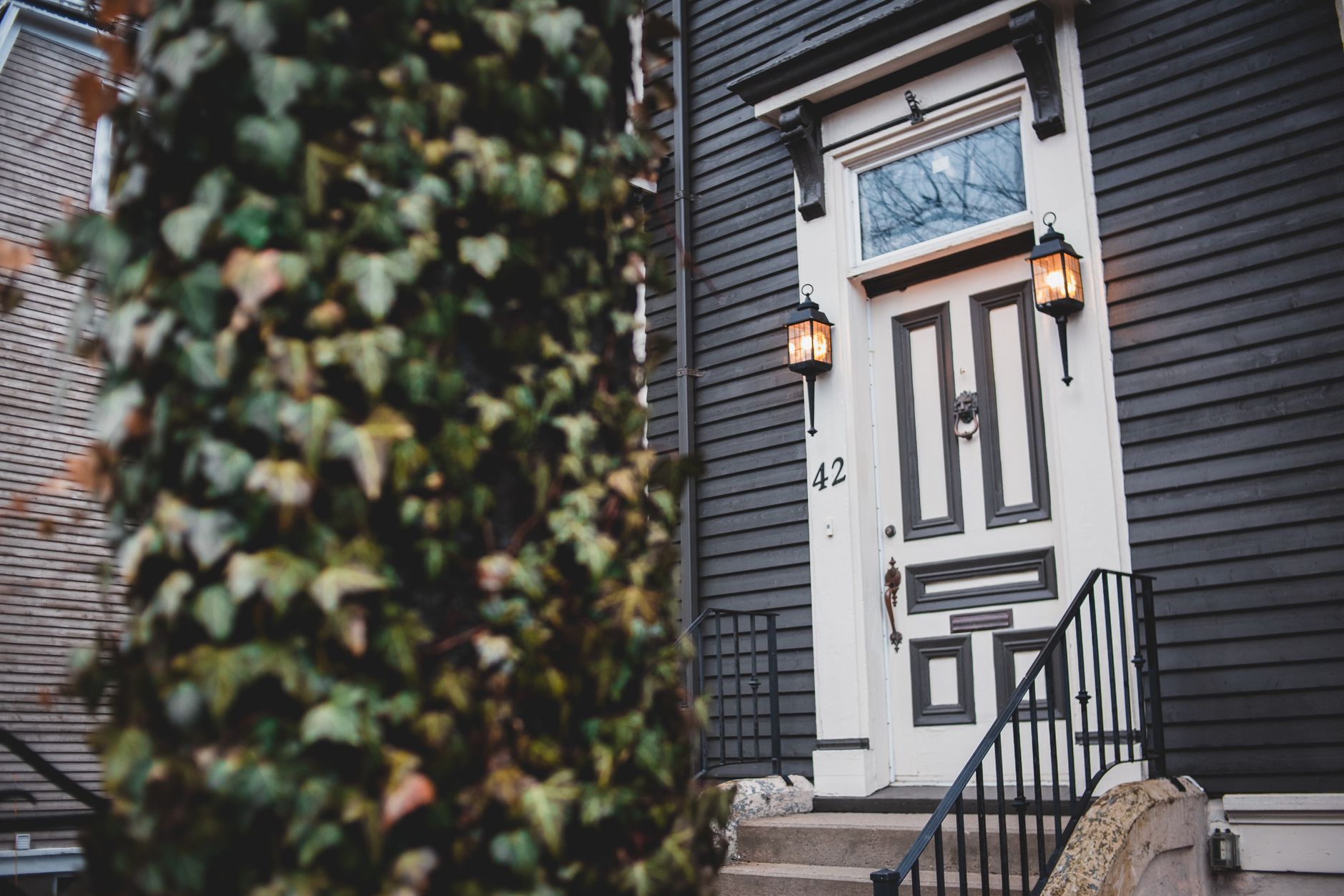 The black front door and porch lanterns of a home, the kind of house buyers often want to tour before reading the agreement
