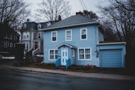 Old residential house trimmed with light blue siding and garage