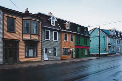 Free Exterior of range of residential houses trimmed with colorful wooden siding in cloudless day in suburbs Stock Photo