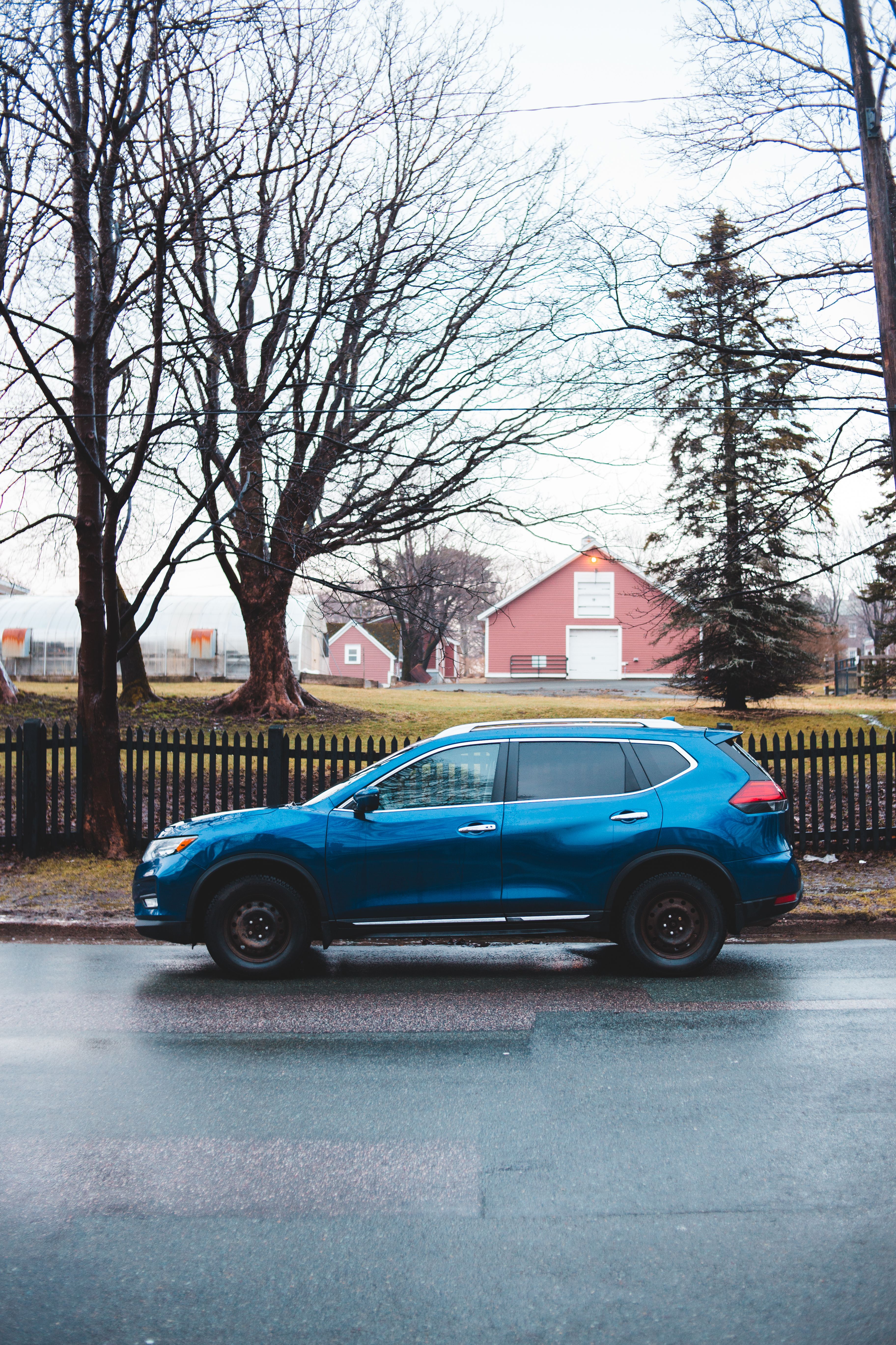 Car parked near tree and house behind fence · Free Stock Photo