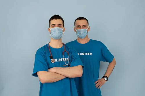 Men in Blue Shirt Wearing Face Mask while Looking at the Camera