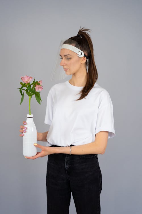 Foto profissional grátis de calças pretas, camisa branca, flores cor-de-rosa