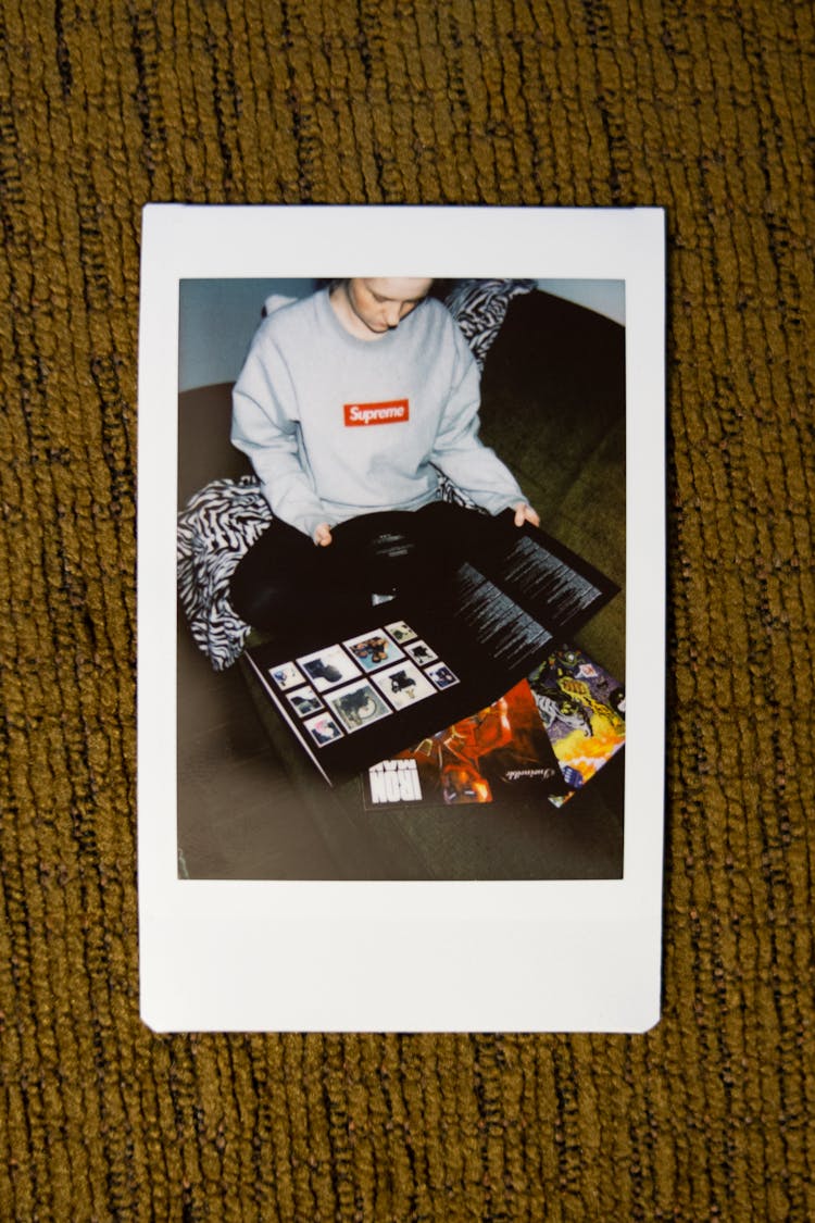 Instant Photo Of Crop Man Sitting And Holding Vinyl Disc