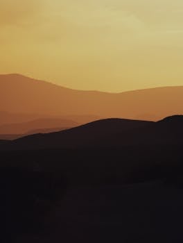 Serene sunset silhouette of desert hills in Joshua Tree, capturing tranquil beauty.
