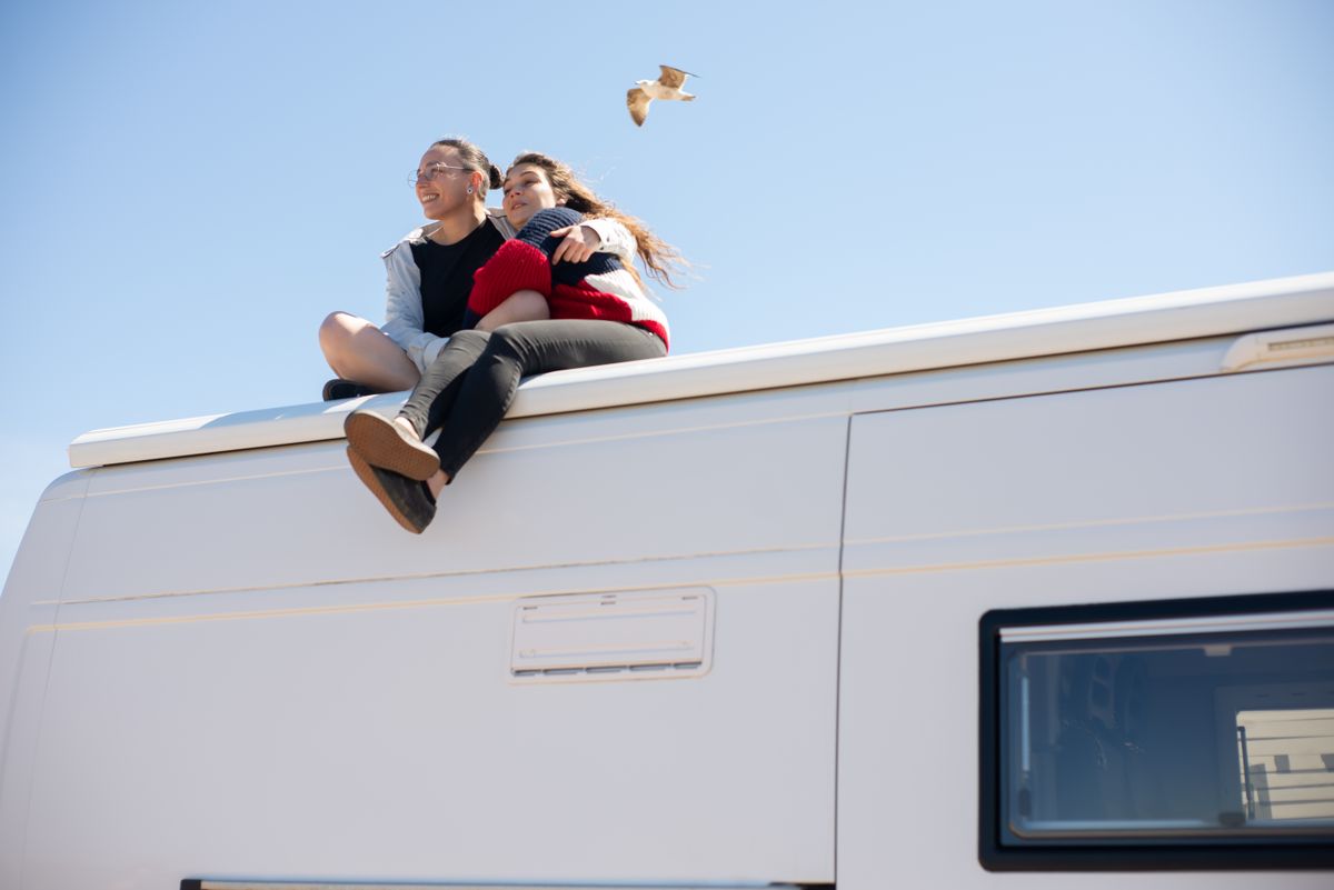 Person inspecting a white RV roof — the first step in any sealing project