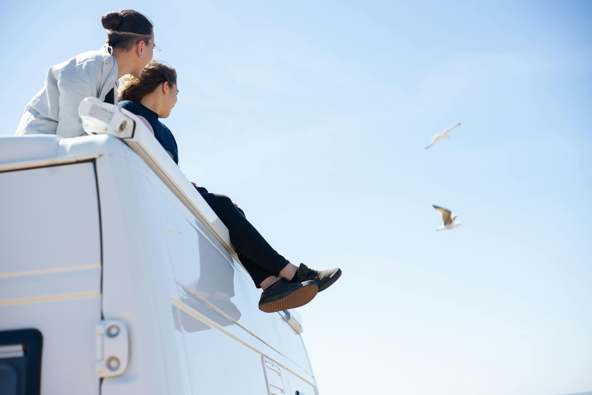 A Couple Sitting on Top of an RV