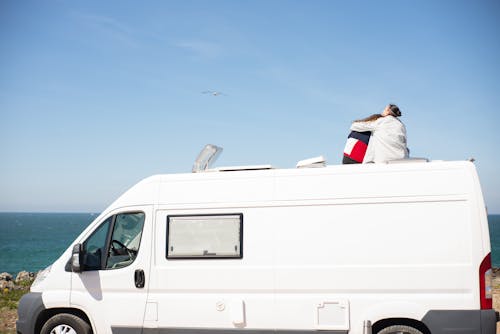 Back View of a Couple Sitting on Top of an RV