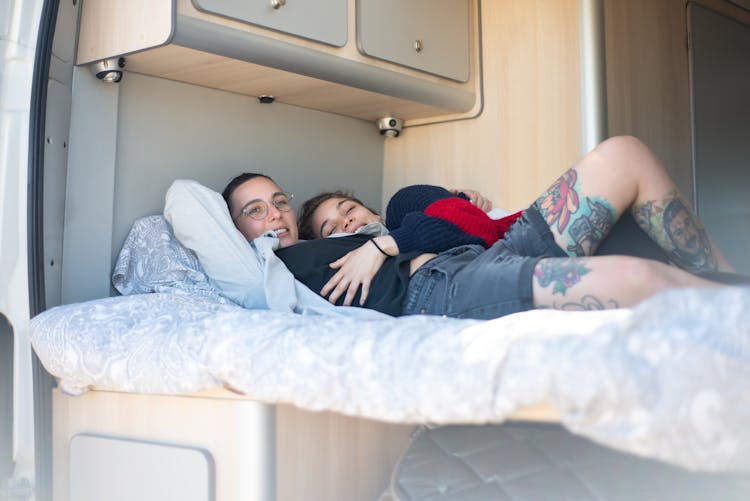 A Couple Lying Together In A Bed Inside A Motorhome