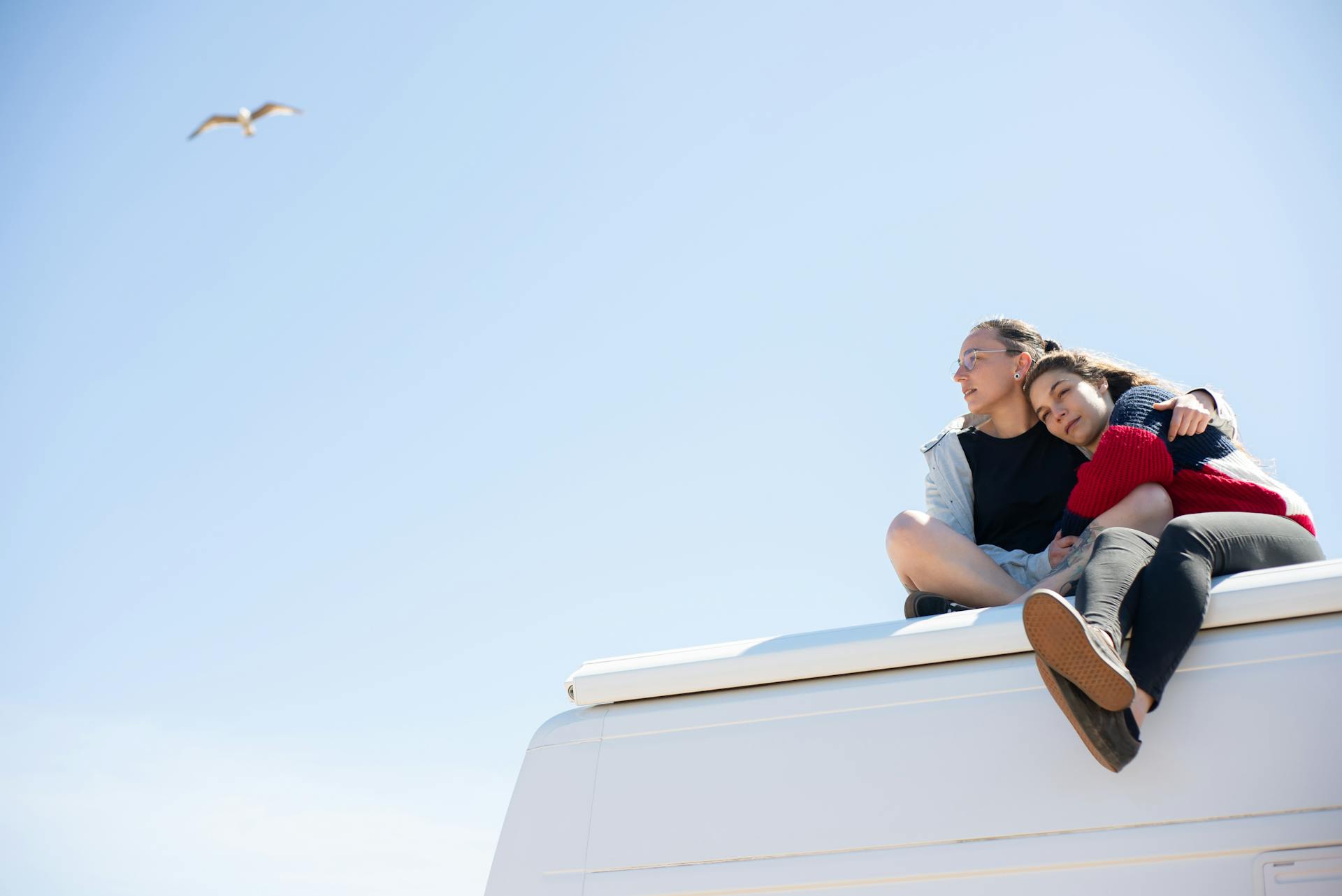 A Couple Sitting on Top of an RV