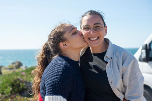 Free Happy couple in love embracing by the coastline in Portugal, showcasing affection and joy. Stock Photo
