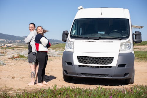 Couple Standing Back to Back Next to Their Van 