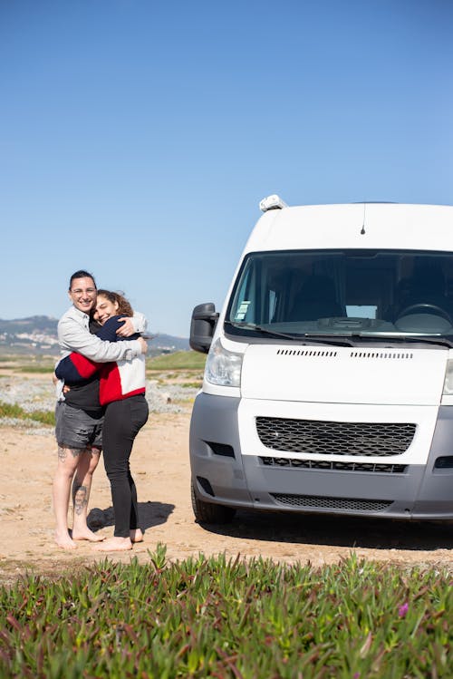 Free Couple Hugging Standing Next to Their Motorhome  Stock Photo