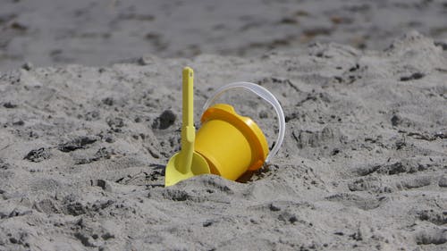 Yellow Plastic Bucket on Sand