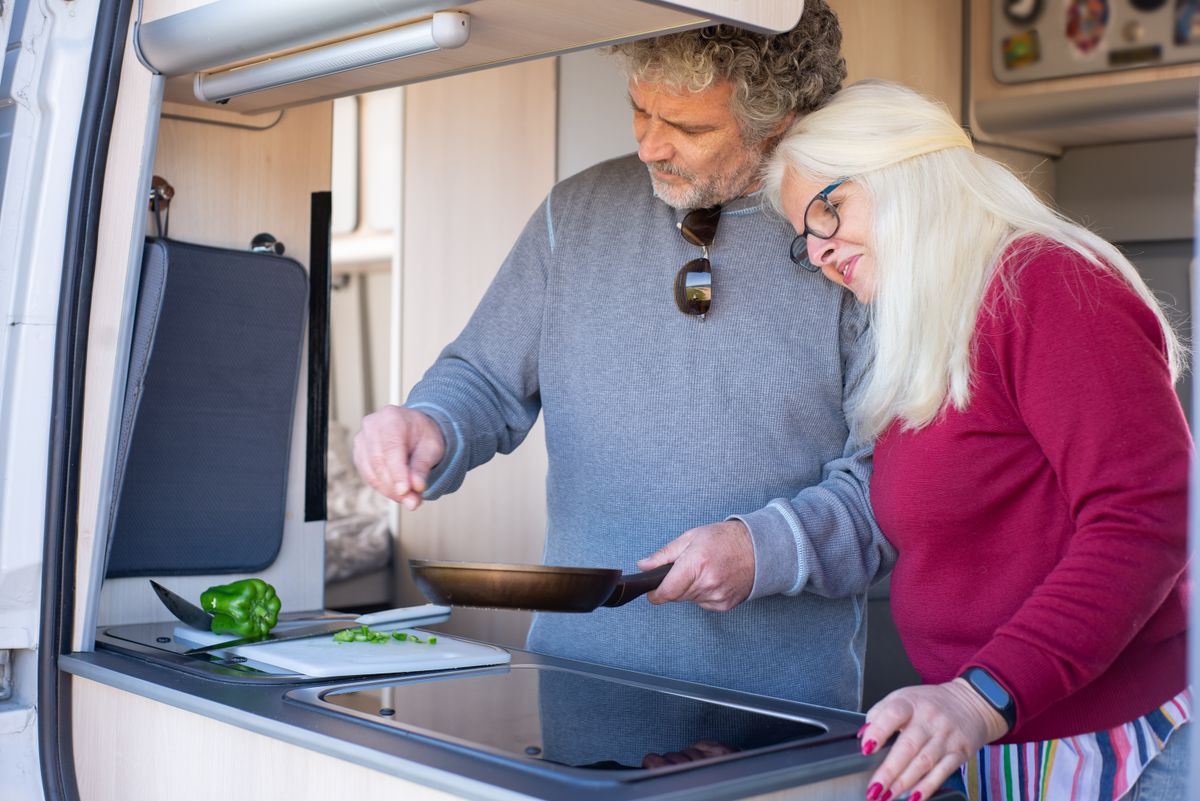 Couple cooking together in a camper van kitchen