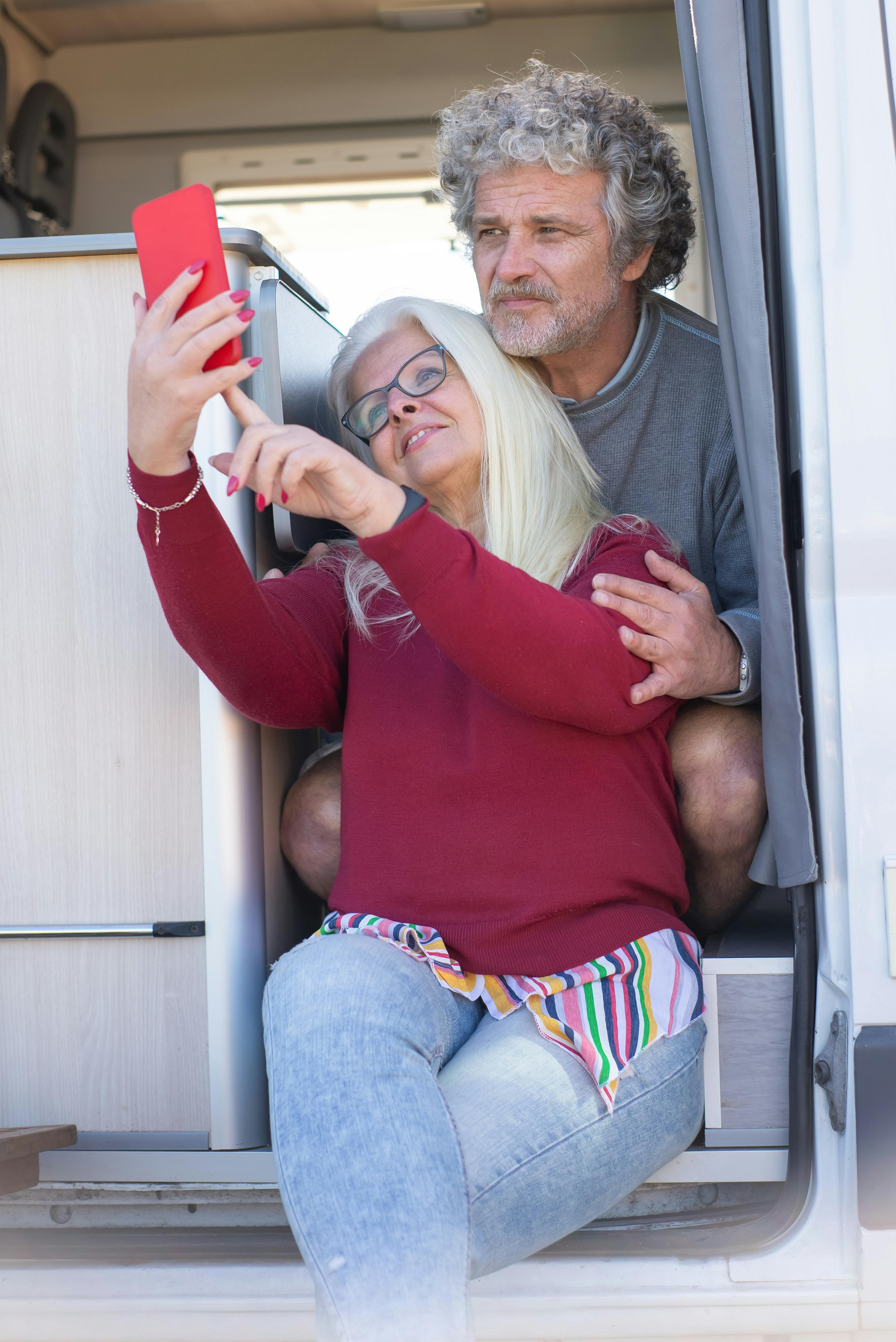 senior couple taking a selfie while sitting in their motorhome