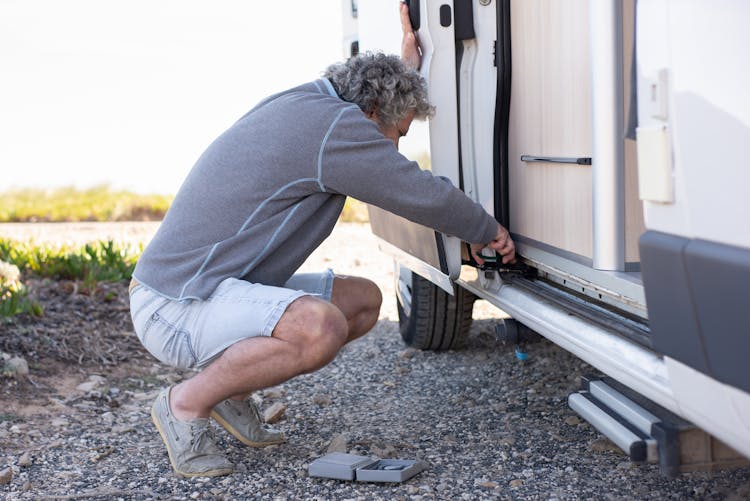 Man In Gray Sweater Fixing The Car 