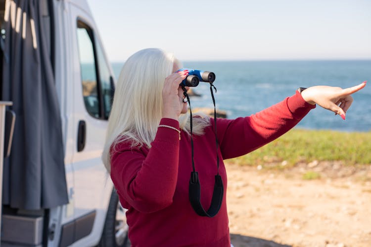 Woman Looking Through Binoculars And Pointing 