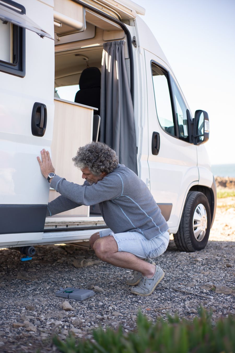 RV camping and maintenance scene, illustrative photo