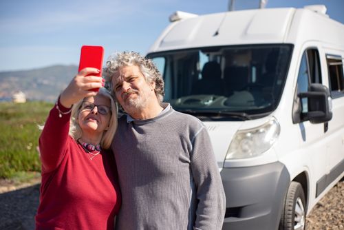 Free Elderly couple taking a selfie during a campervan road trip in sunny Portugal. Stock Photo