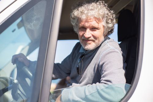 Free Senior man with gray hair driving a car in Portugal on a sunny day. Stock Photo