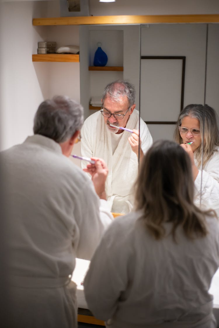 Two People Brushing Their Teeth