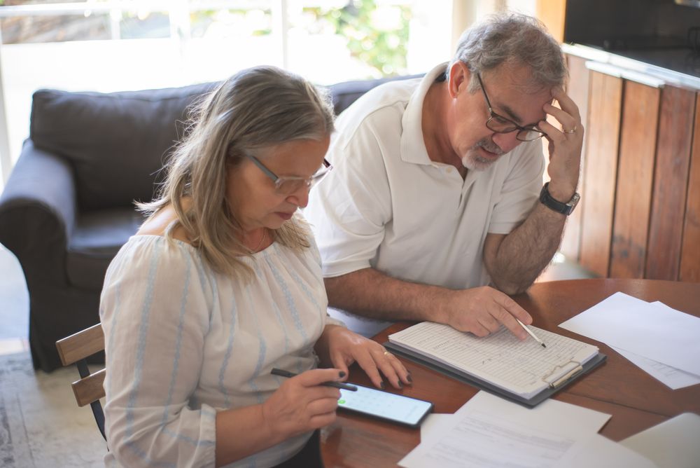 Older couple reviewing household bills and financial documents together