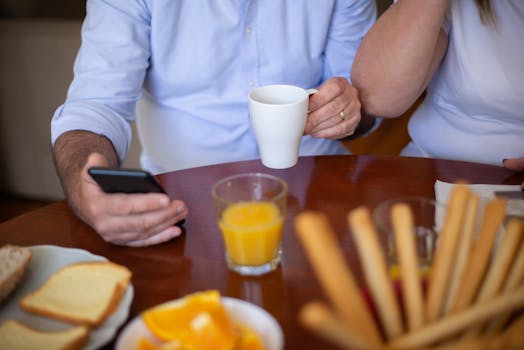 A relaxed breakfast scene featuring a smartphone and a ceramic mug, perfect for lifestyle content.