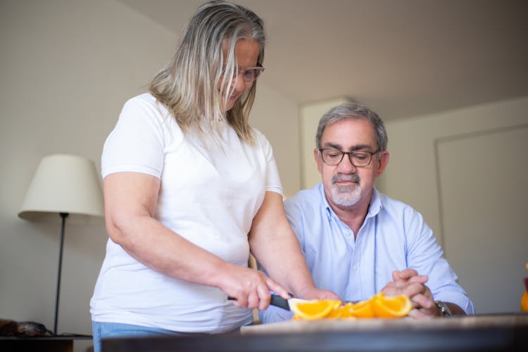 Woman And Man Cutting Oranges