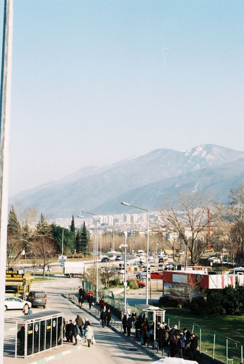 Free Urban street scene with mountains and clear sky, capturing daily life and city vibes. Stock Photo