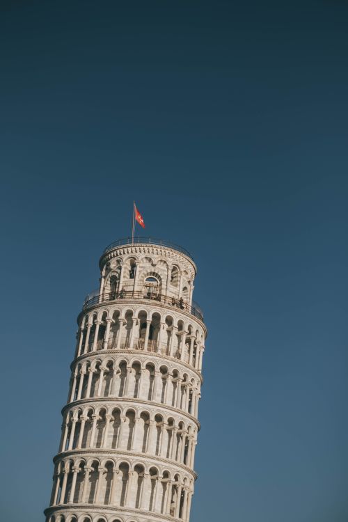 Free Iconic Leaning Tower of Pisa under a clear blue sky in Italy. Stock Photo