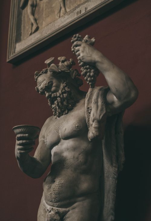 Free Statue of Dionysus holding grapes and cup in an Italian museum. Stock Photo