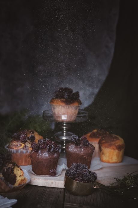 Dusted berry cakes on a stand in low, moody light — photo by Büşra Akkaya on Pexels