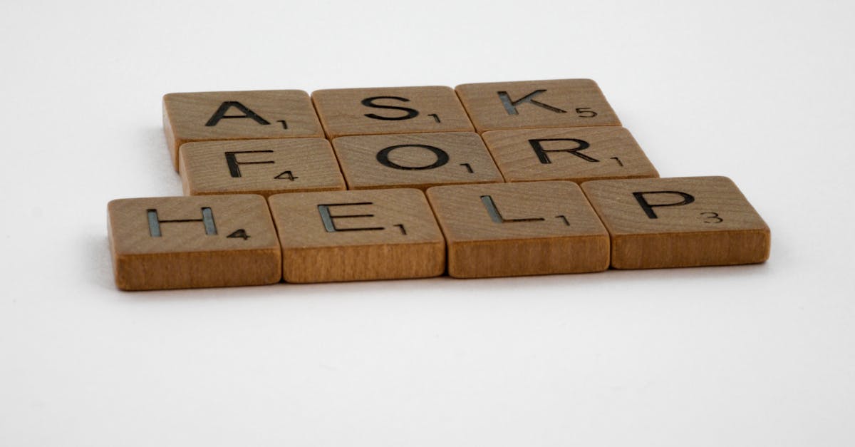 Scrabble tiles arranged on a white background forming the phrase 'Ask for Help', conveying a message of communication.