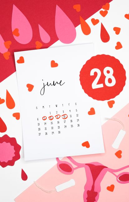 Artistic still life of a June calendar with heart and blood drop cutouts symbolizing the menstrual cycle.