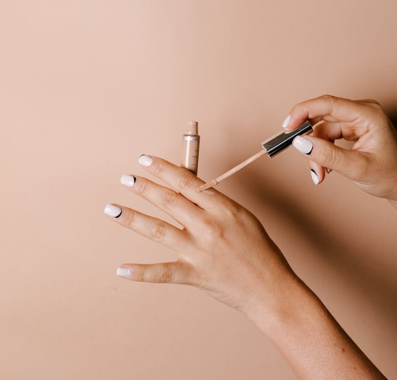 Free A Person Applying Concealer on Her Hand Stock Photo