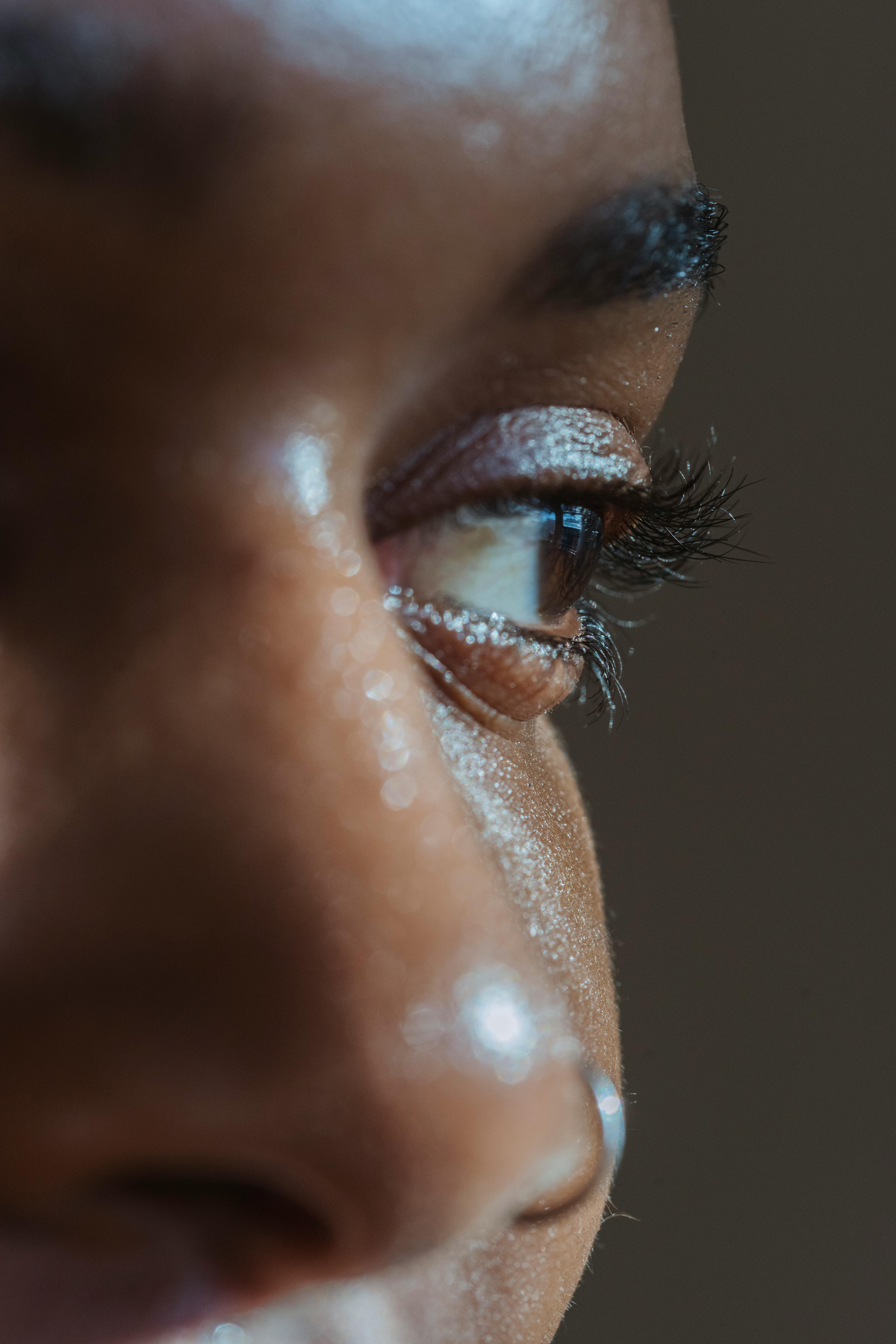 Detailed close-up of a human eye focusing on eyelashes and skin texture under natural light.