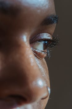 Detailed close-up of a human eye focusing on eyelashes and skin texture under natural light.
