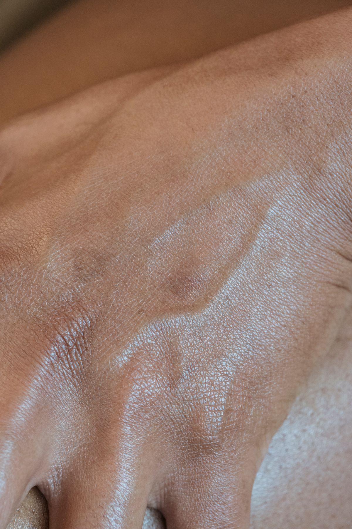 Close-up da pele da mão com veias visíveis usado como teste para identificar subtom