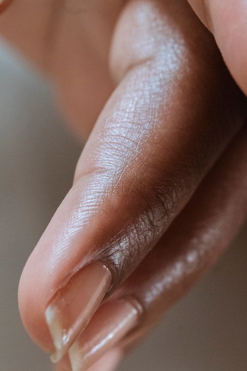 Free Detailed close-up of a manicured fingernail on smooth dark skin, showcasing natural beauty and care. Stock Photo