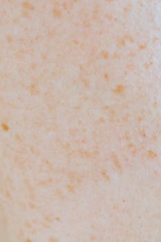 An extreme close-up of human skin showing freckles and texture, ideal for dermatology studies.