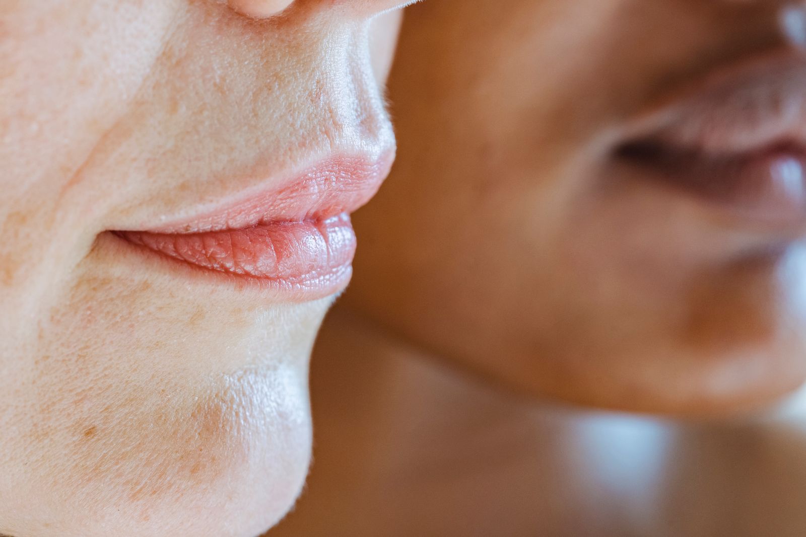 A close view of two women showing different natural skin tones and textures