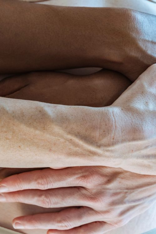 Free Crop anonymous multiethnic couple delicately hugging nude belly of pregnant woman expecting baby Stock Photo