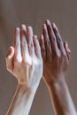Crop anonymous multiethnic females showing hands together as concept of difference in studio