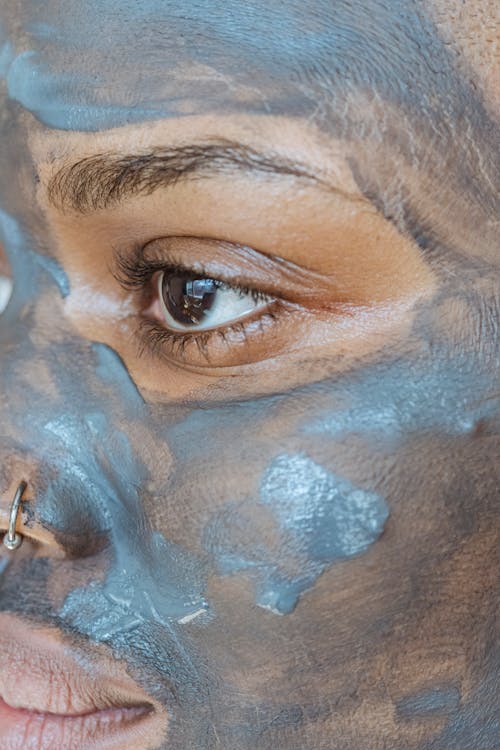 Free Serious black woman with clay mask for beauty procedure Stock Photo