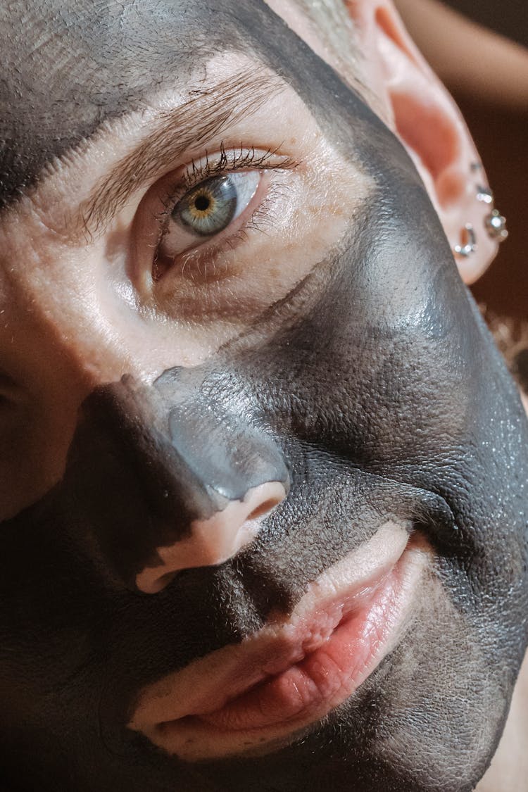 Woman With Clay Mask Applied On Skin