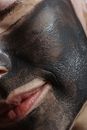 Chin and cheek of crop woman with clay mask