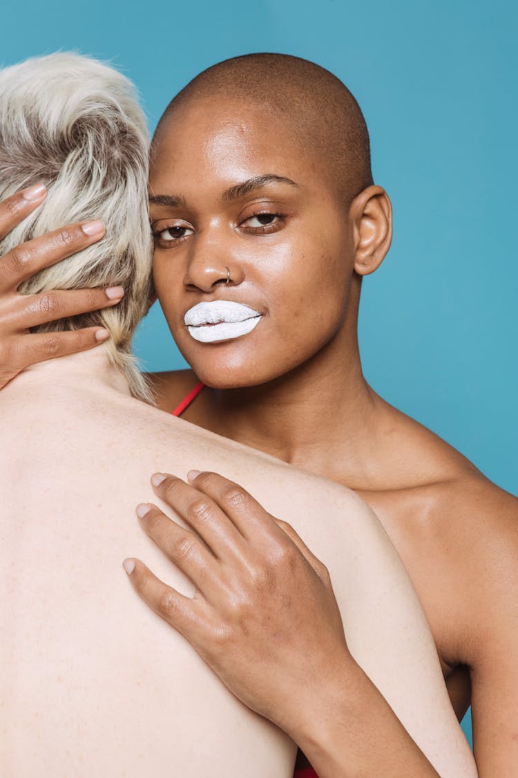 Multiracial Friends With White Lips Embracing In Studio