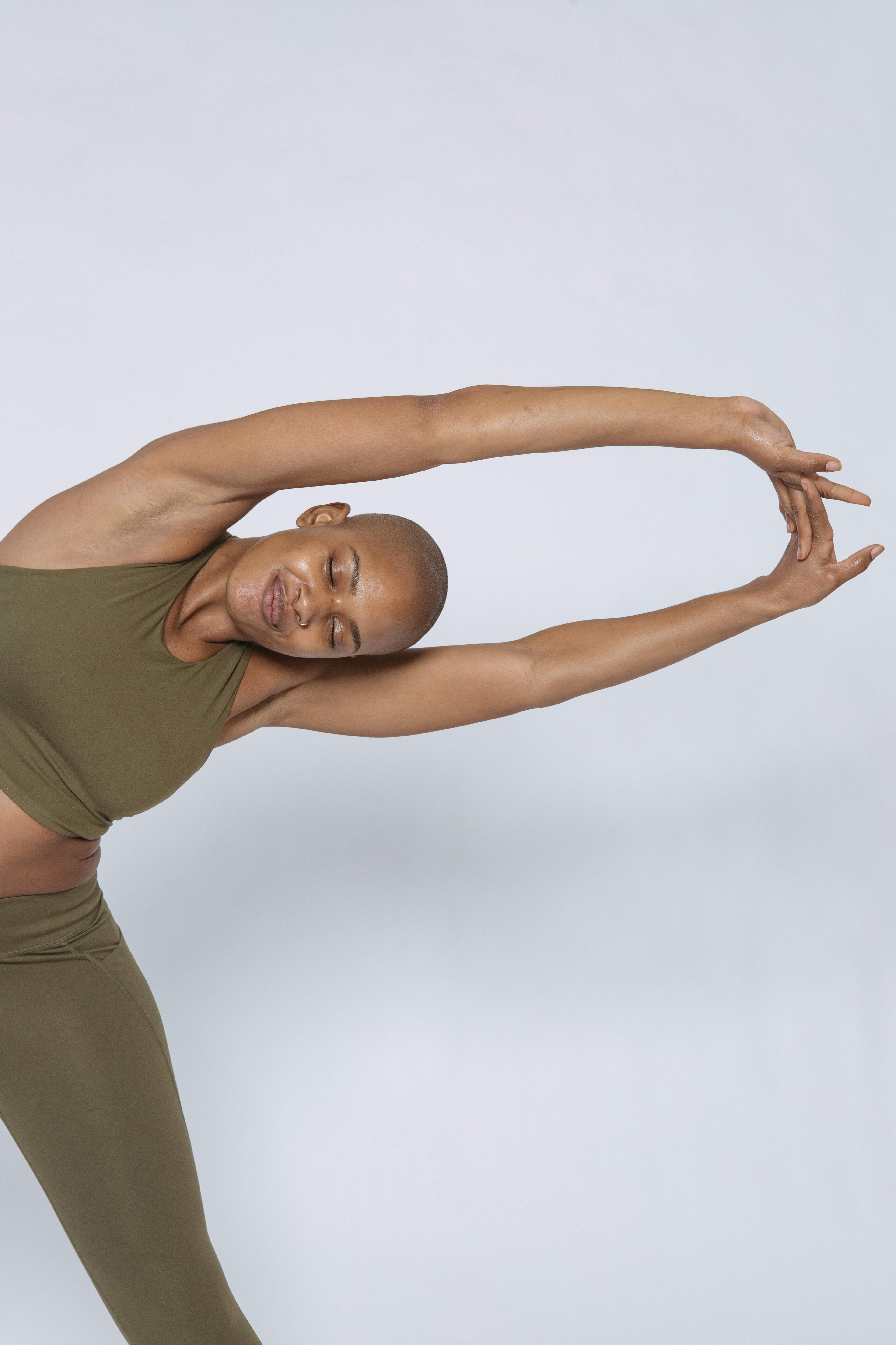 woman closing eyes while straightening arms and bending aside