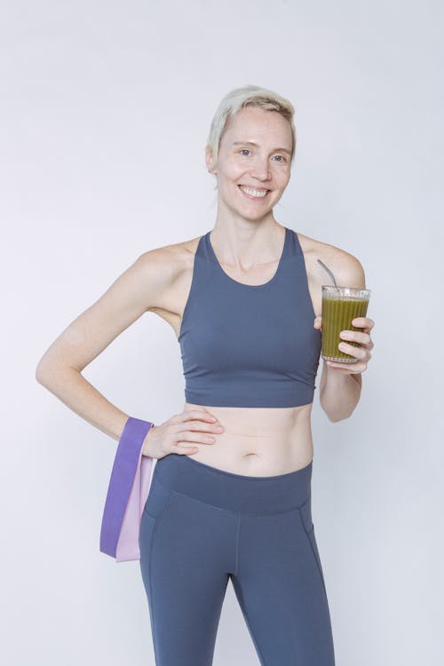 Free Slim woman with glass of smoothie and resistance band Stock Photo