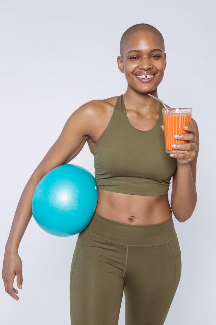 Smiling Black Woman With Glass Of Carrot Smoothie For Detox